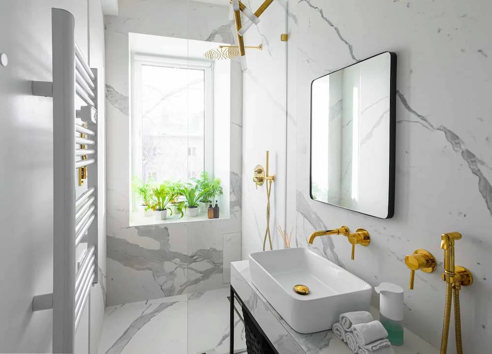 modern luxury bathroom interior with white marble tiles golden accessories